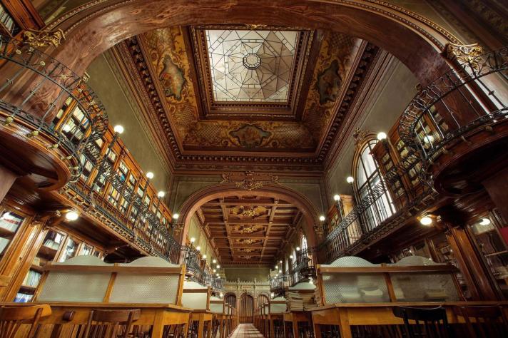 Image of the old and beautiful Technical University "Gheorghe Asachi" Library of Iasi with books stored on two floors and desks to read separated with semi-transparent partitions 