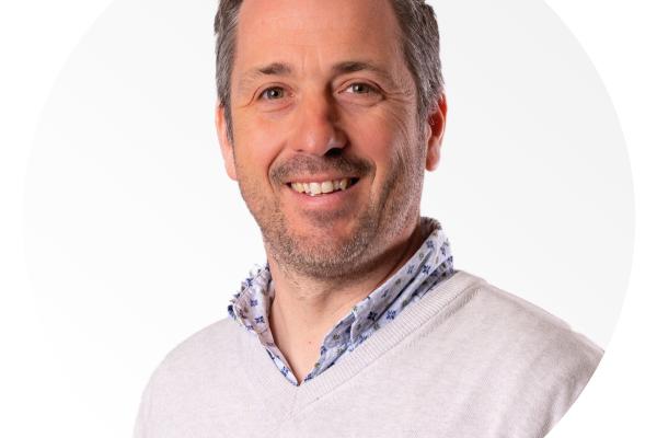Headshot of Frédéric Coupain, the interviwee looking at the camera smiling, wearing a beige sweater and with a white background