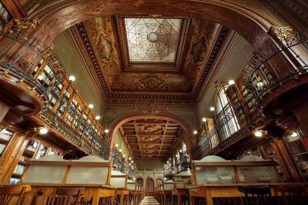 Image of the old and beautiful Technical University "Gheorghe Asachi" Library of Iasi with books stored on two floors and desks to read separated with semi-transparent partitions